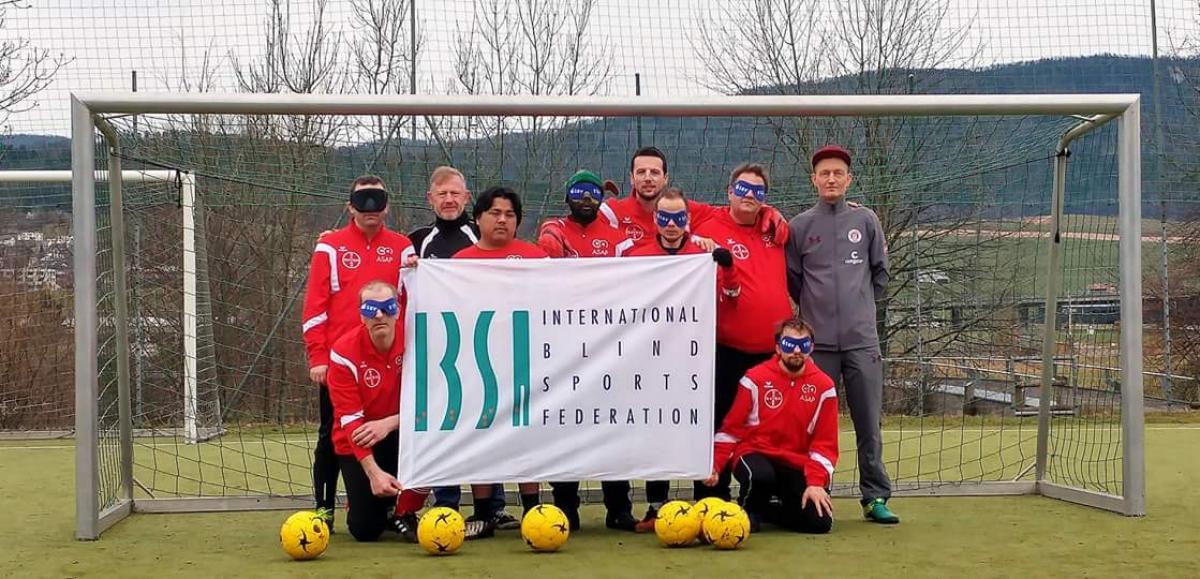 a group of blind footballers line up in goal