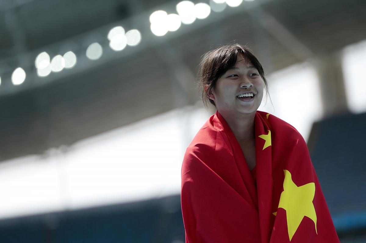 a female Para athlete wrapped in the Chinese flag