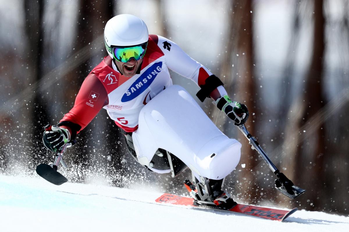 a male sit skier goes down the slope