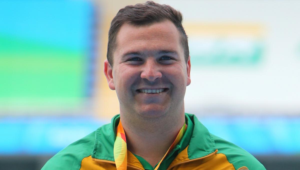 a male athlete smiling on the podium
