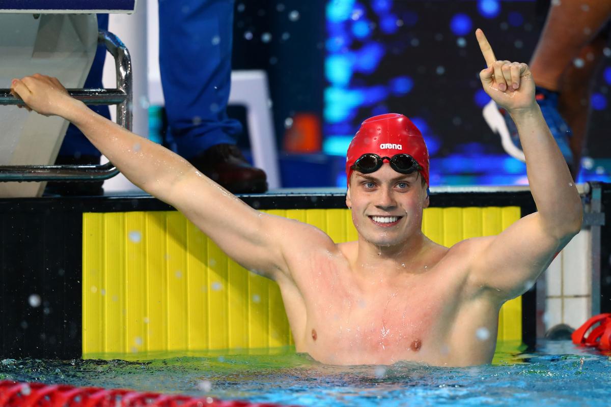 a male Para swimmer celebrates his win in the pool
