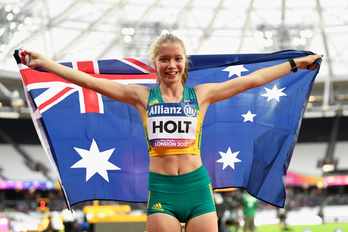 a female Para sprinter holding up the Australian flag