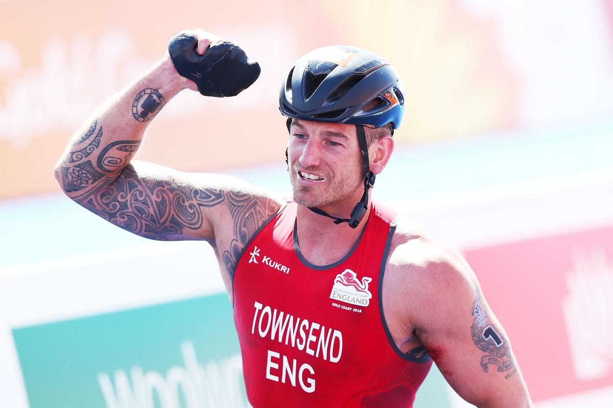 a male Para triathlete celebrates winning the race