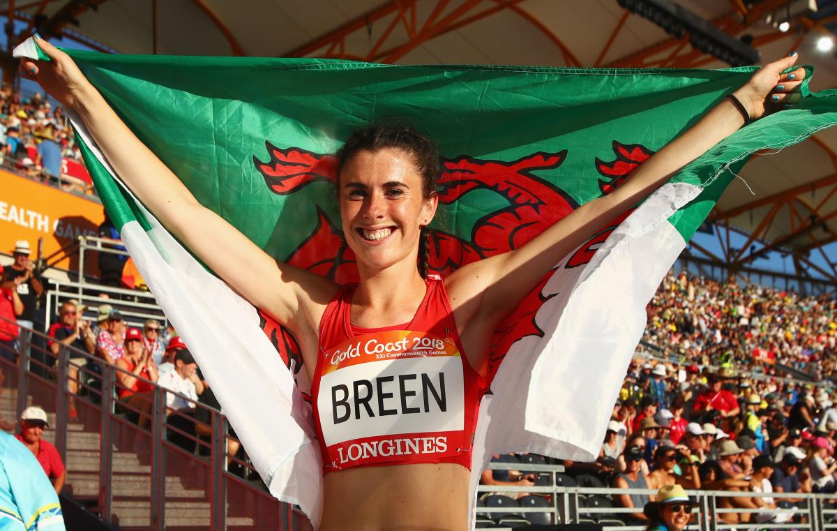 Olivia Breen - Gold Coast 2018 a female Para athlete holding up the Welsh flag