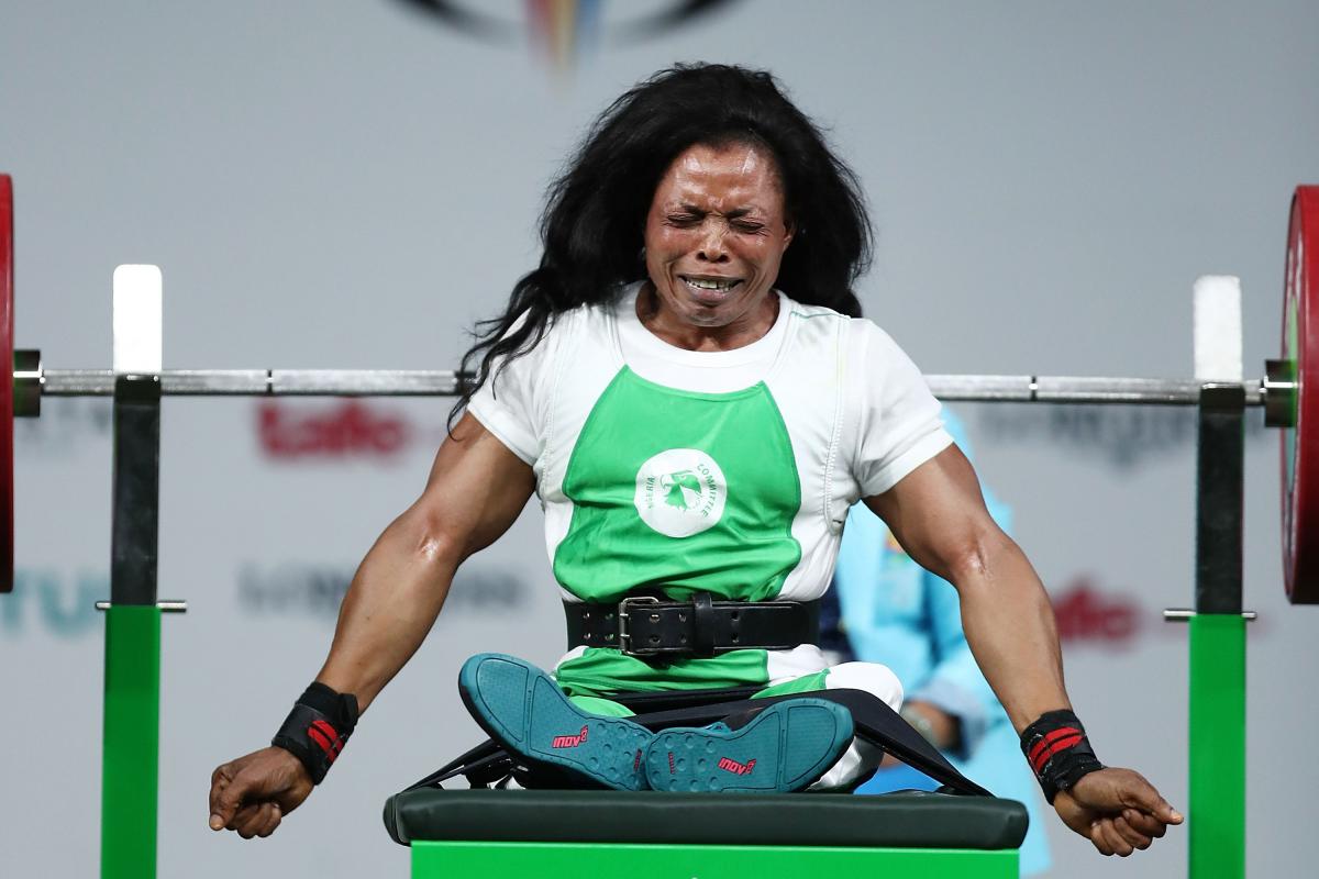 a female powerlifter celebrates on the bench