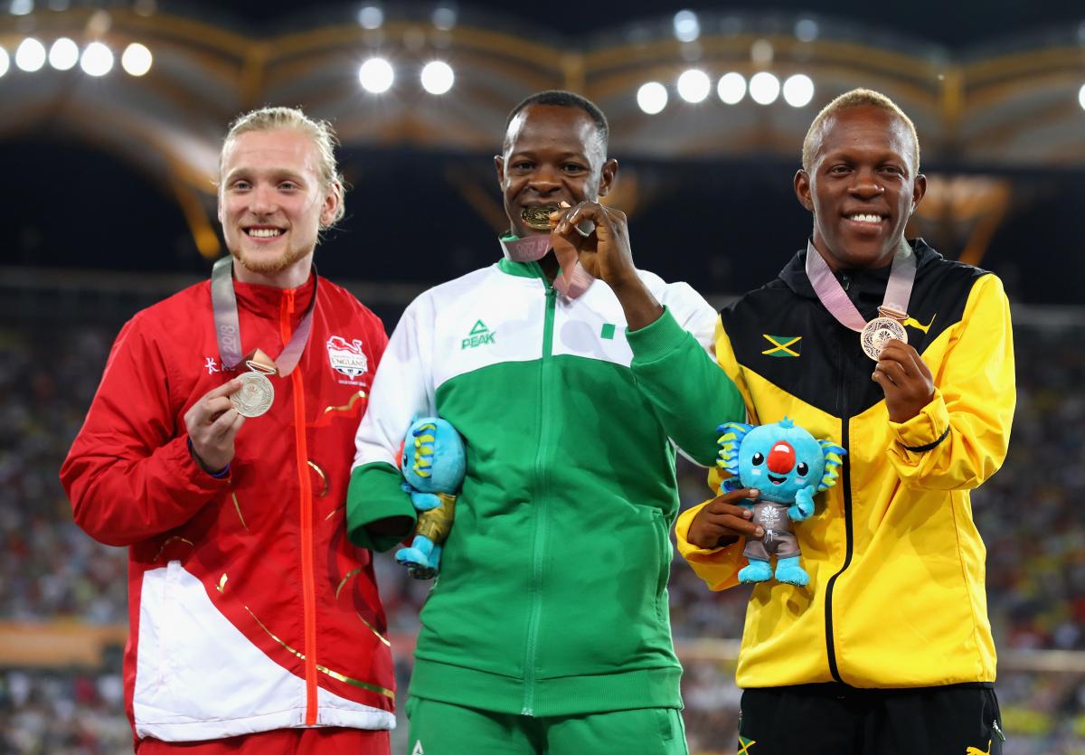 Suwaibidu Galadima celebrating on the podium together with James Arnott and Tevaughn Thomas at Gold Coast 2018.