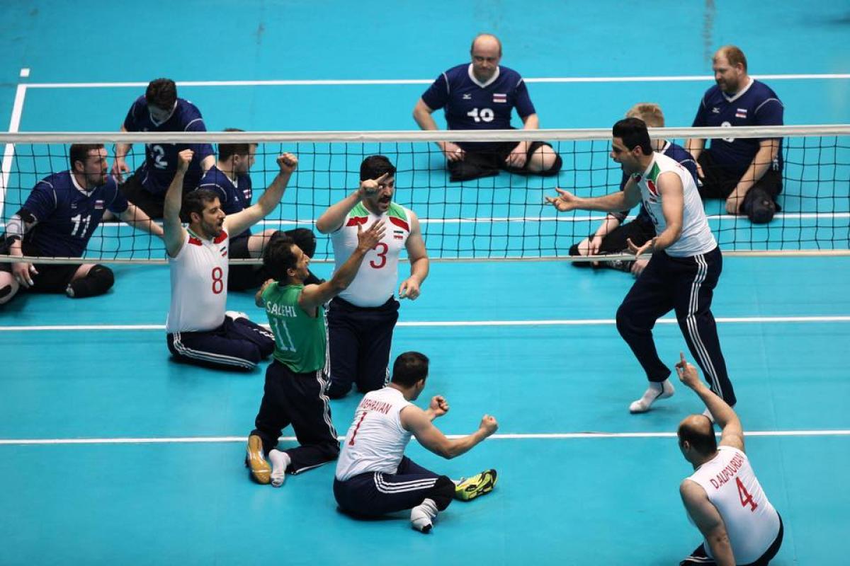 Iran win Super 6 a group of male sitting volleyball players celebrate on the court
