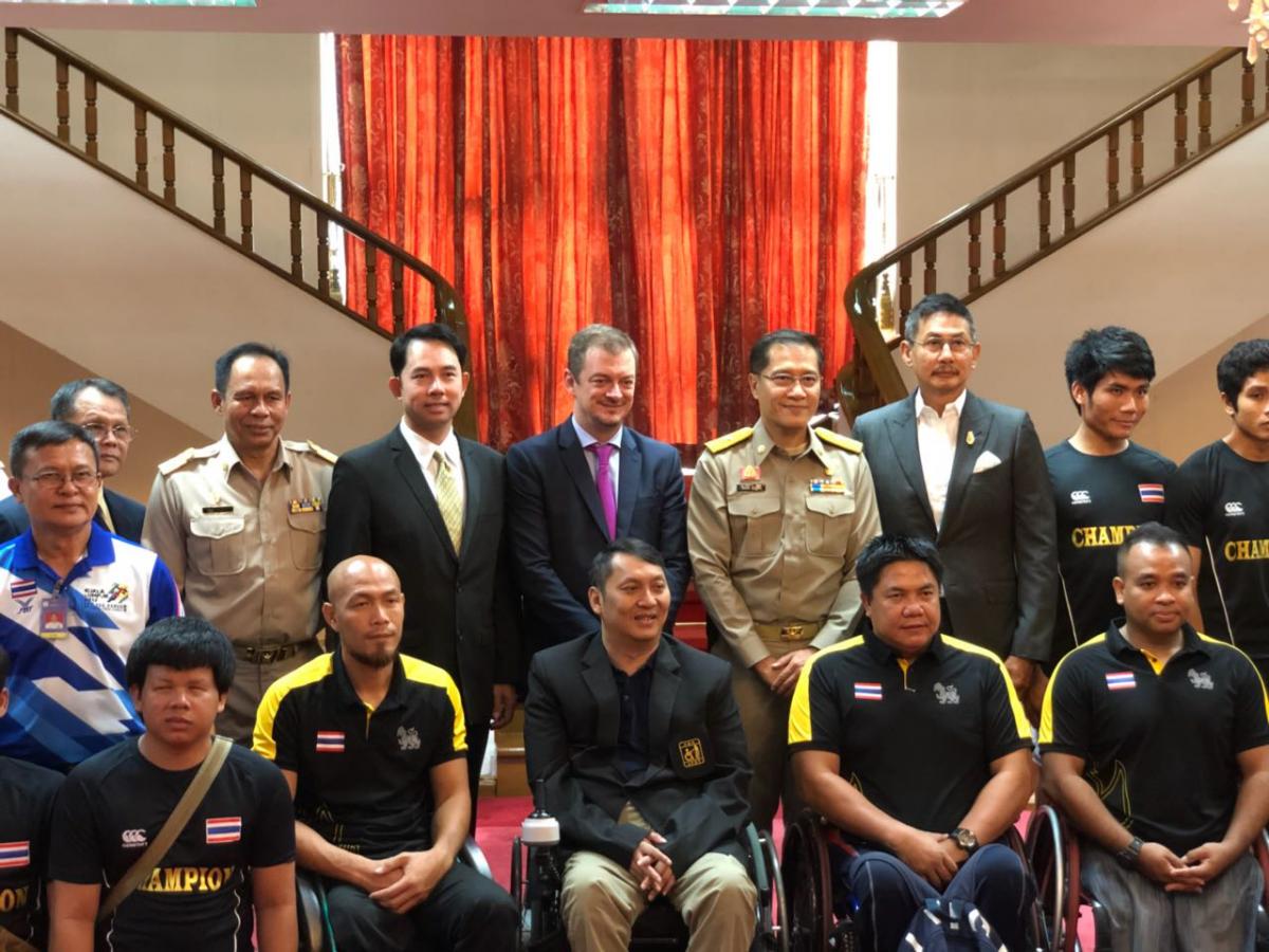 a group of officials and wheelchair athletes standing together