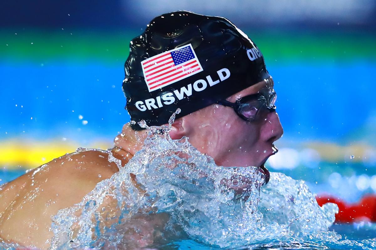 a male Para swimmer mid breaststroke