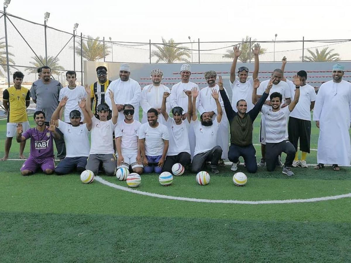 a group of blind footballers line up on a pitch