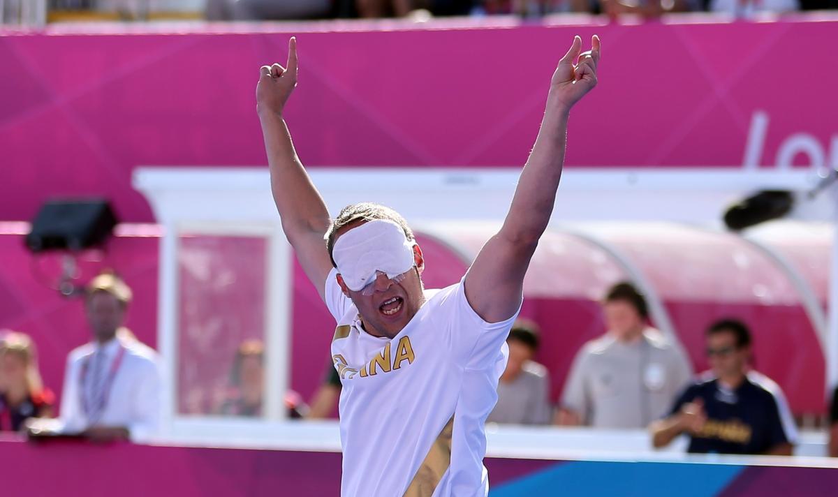 a blind footballer raises his arms in celebration