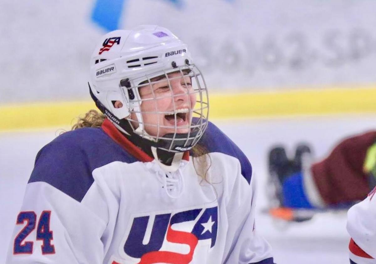 a female Para ice hockey player laughing on the ice