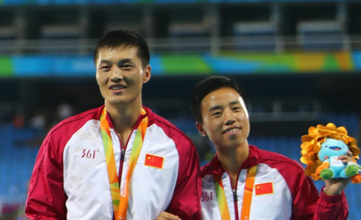 a female vision impaired athlete and her male guide on the podium