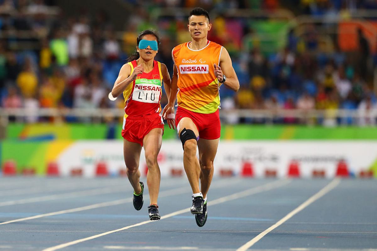 Two runners sprint towards the finish line. 