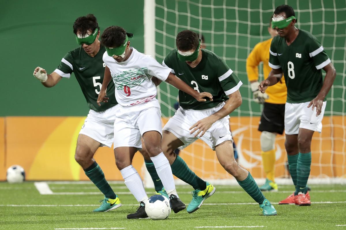 a group of blind football players in action on the pitch