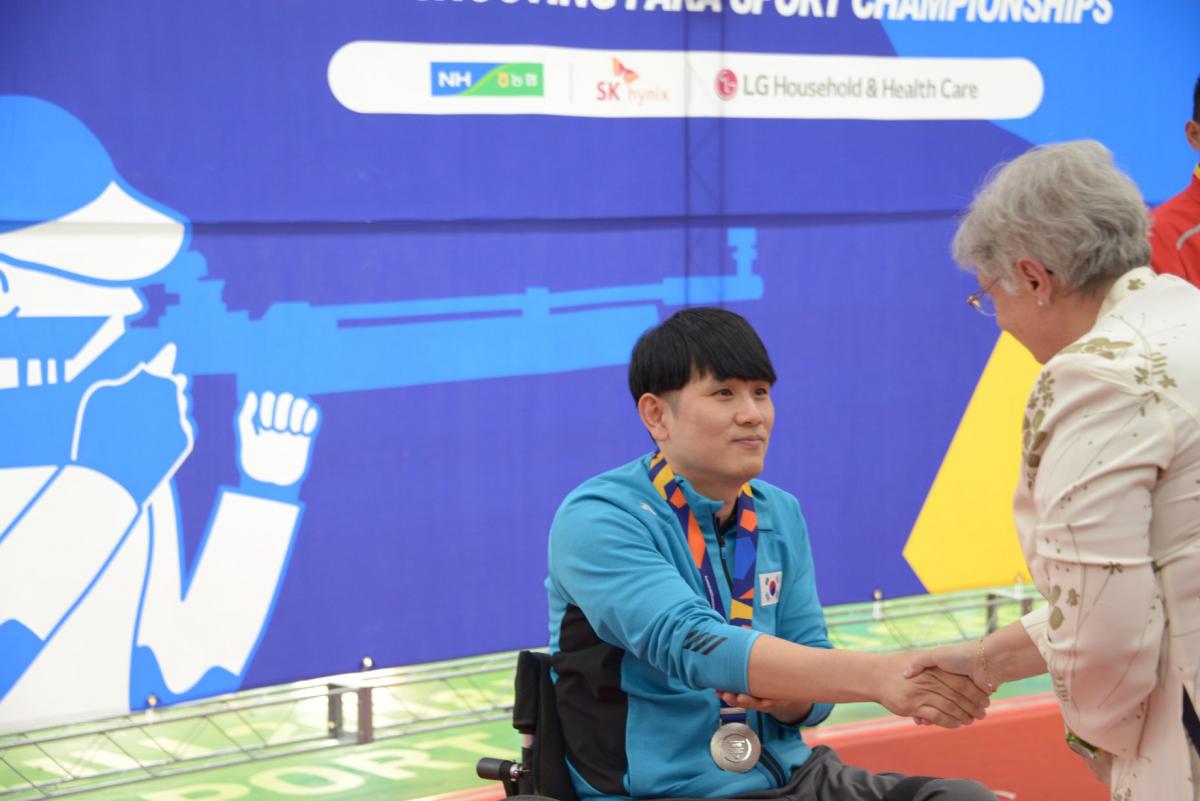 a male Para shooter receives his medal