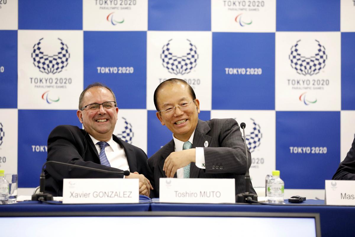 two men smiling and shaking hands