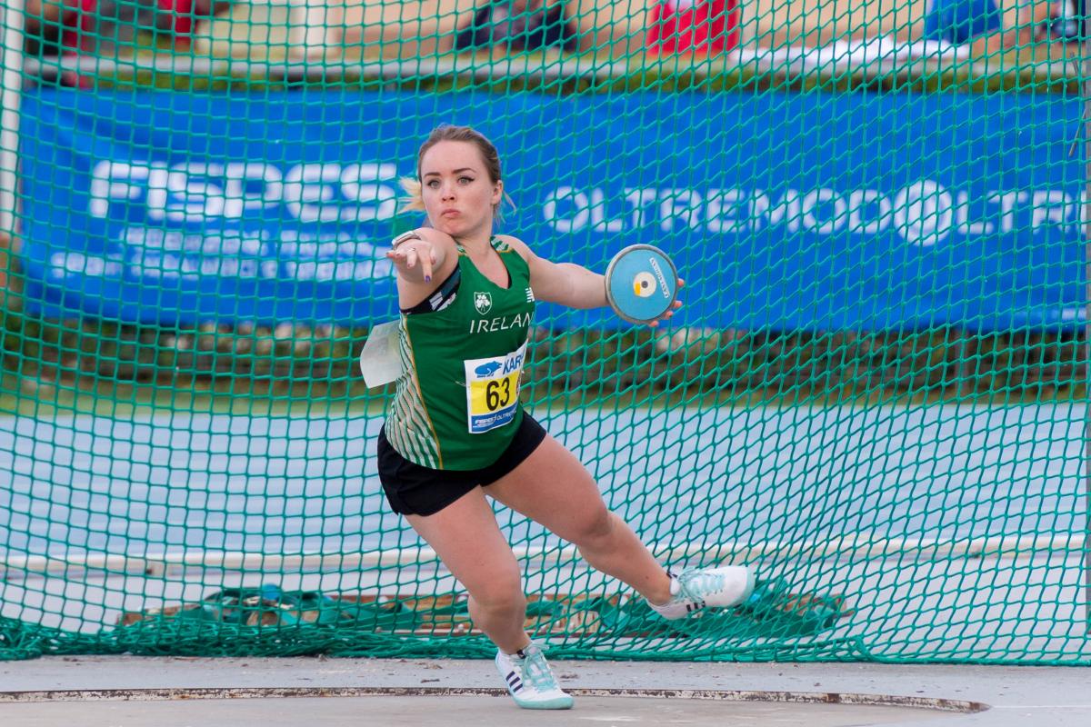 Short statured female discus thrower competing