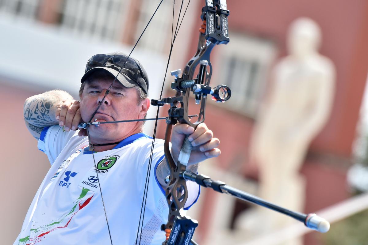 a male Para archer prepares to shoot an arrow