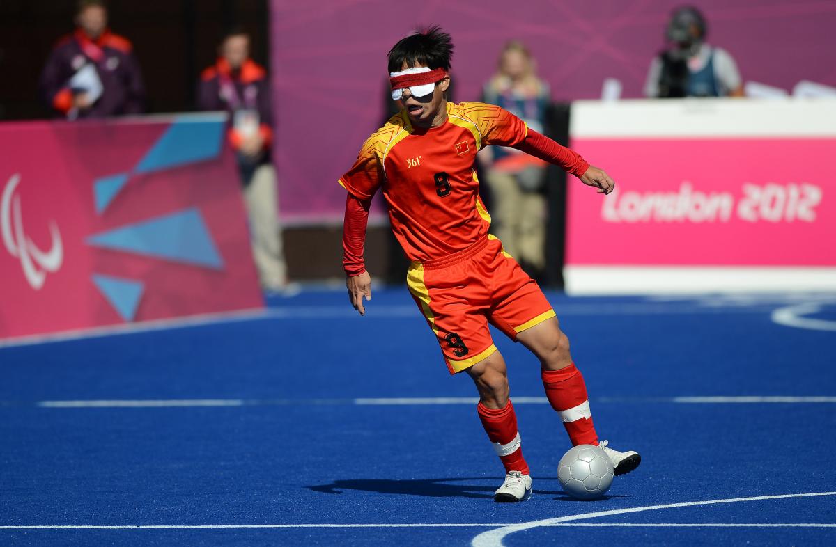 a blind football player dribbling with the ball