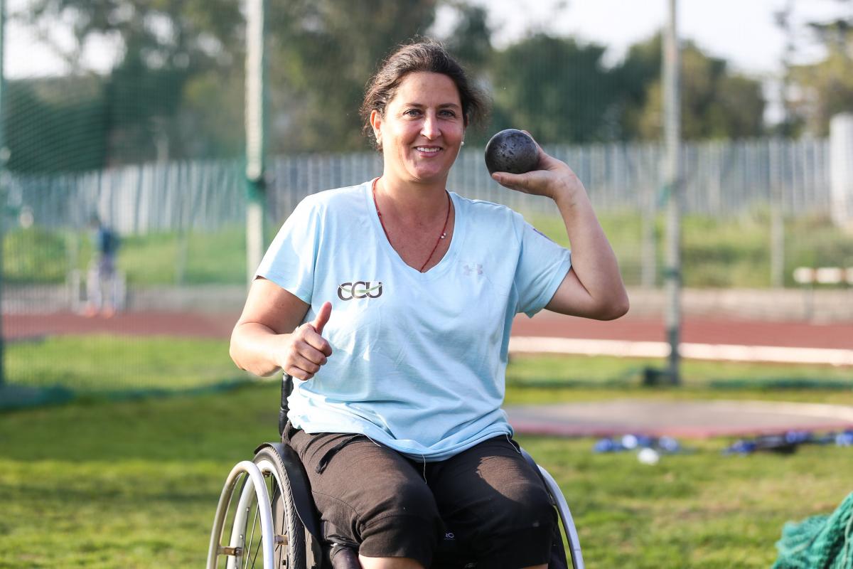 a female Para athlete prepares to throw a shot put