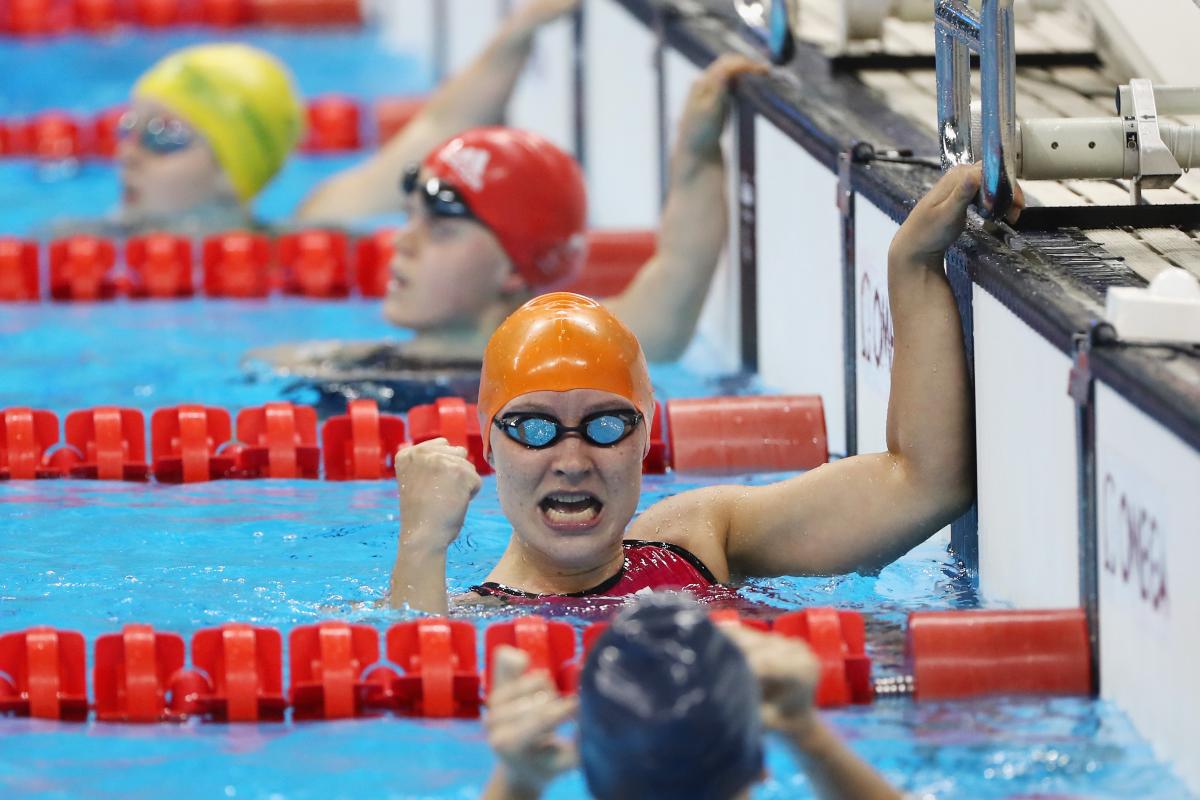 Yelyzaveta Mereshko a female Para swimmer punches in the air in the pool