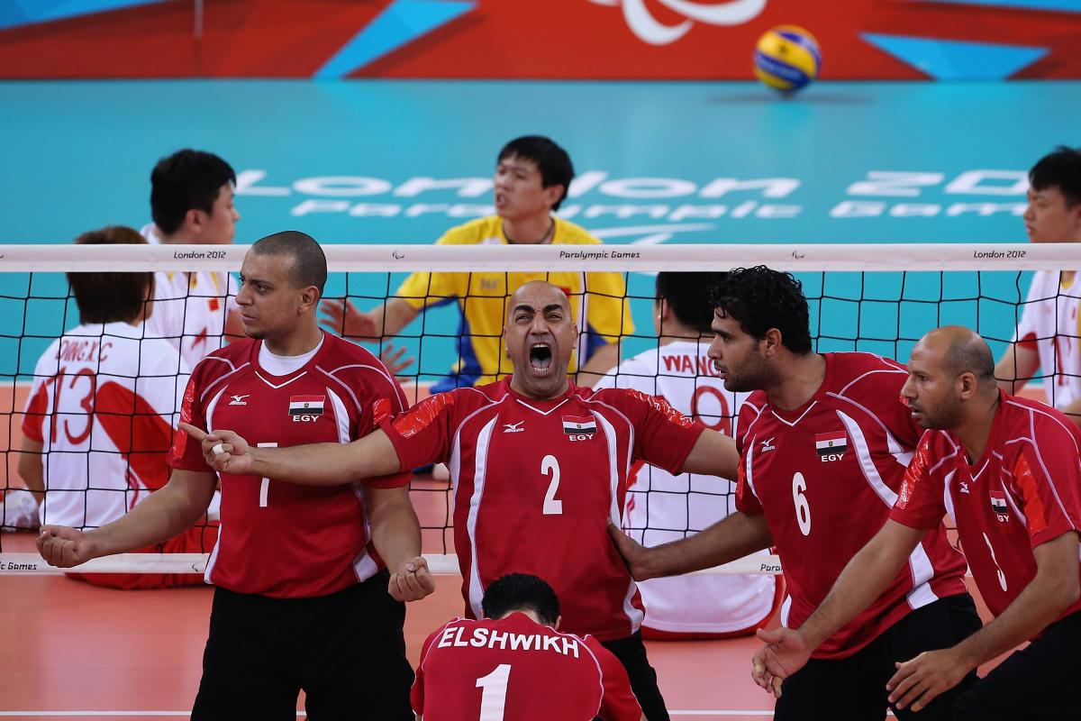 a men's sitting volleyball celebrate and shout on the court