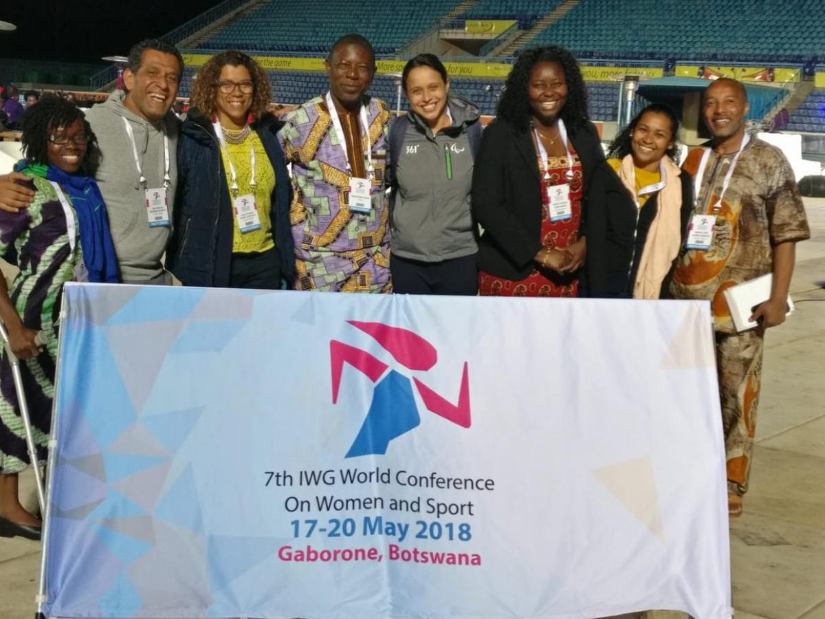 a group of women standing behind a flag