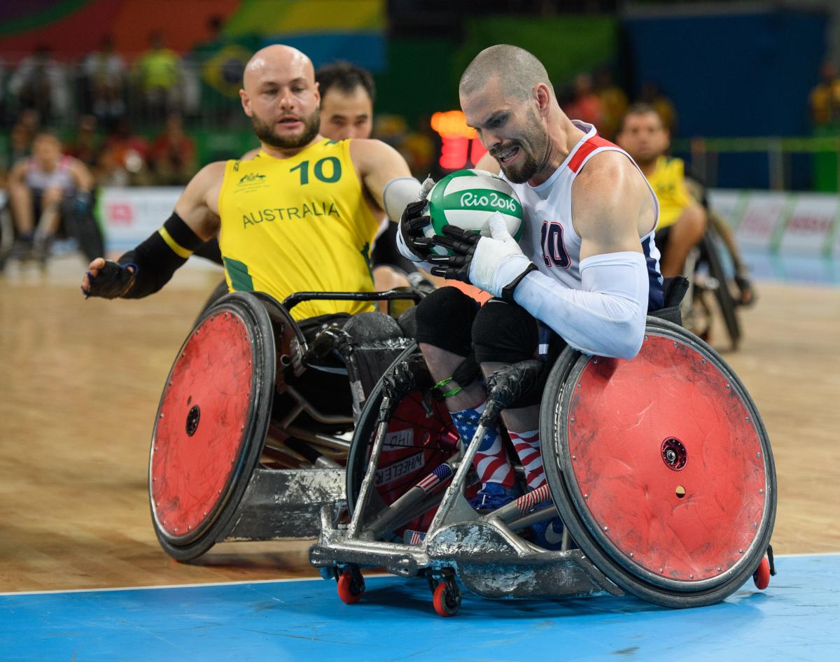 two male wheelchair rugby players fight for the ball