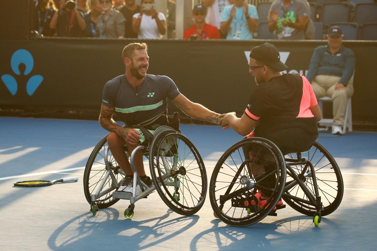 Two men in wheelchairs shake hands