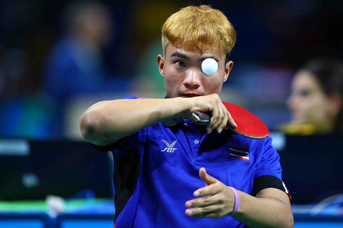 Man trying to hit a table tennis ball