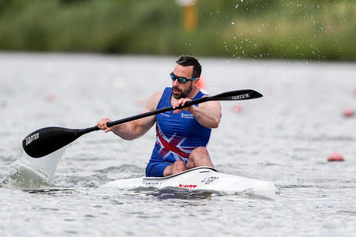 a male canoeist paddles on the water