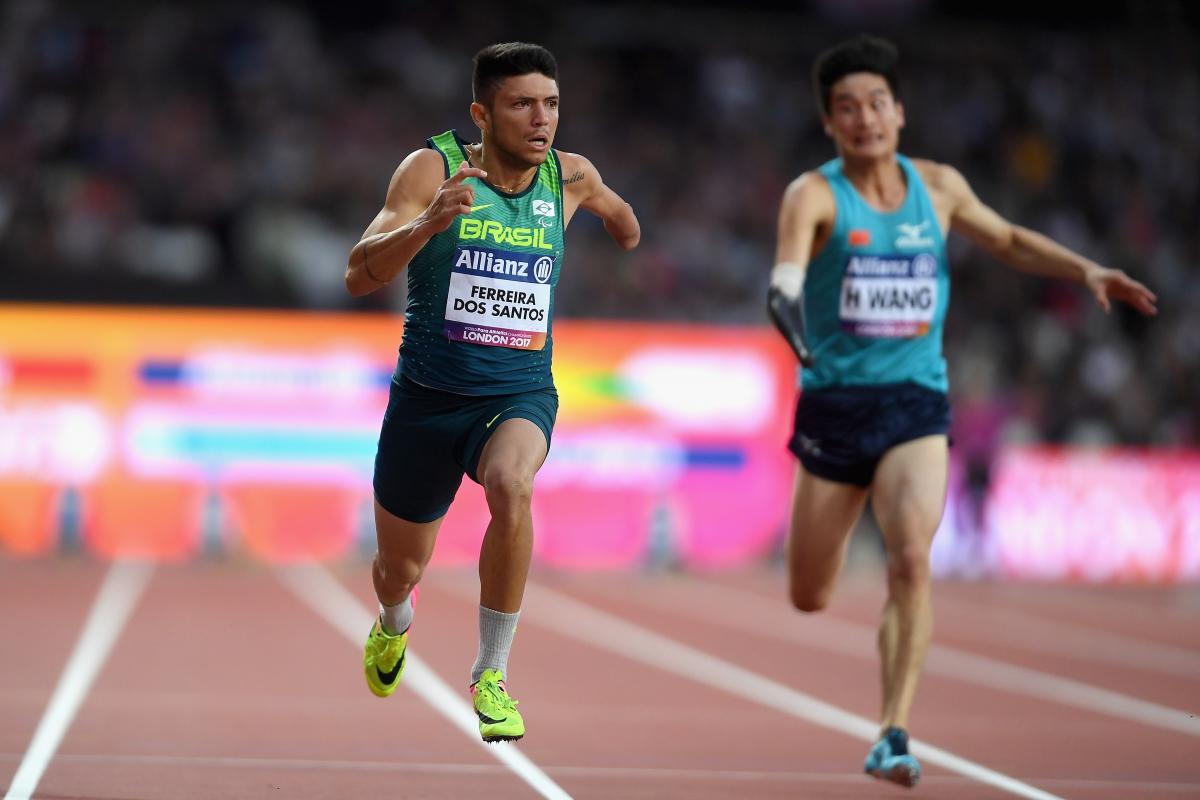 a male Para sprinter crosses the finish line