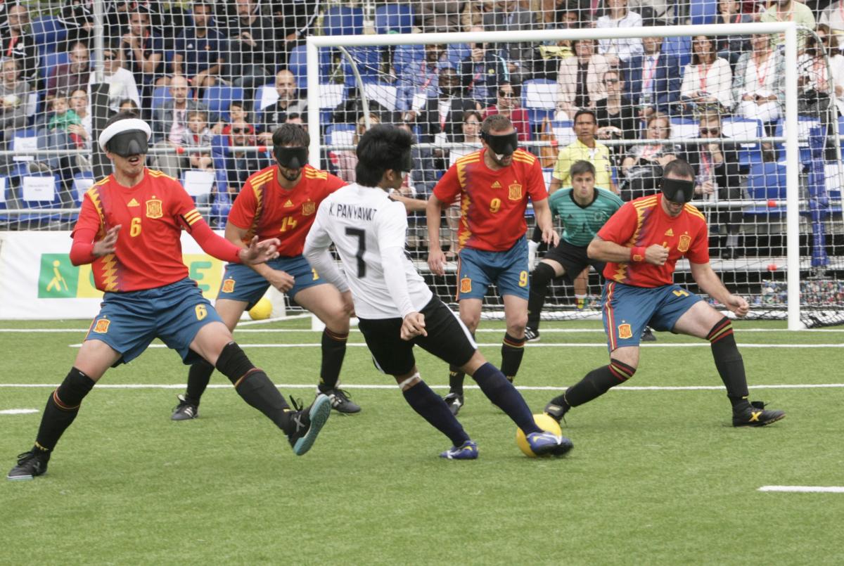 a group of blind footballers in action on the pitch