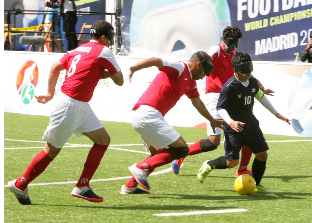 a group of blind footballers contesting a ball