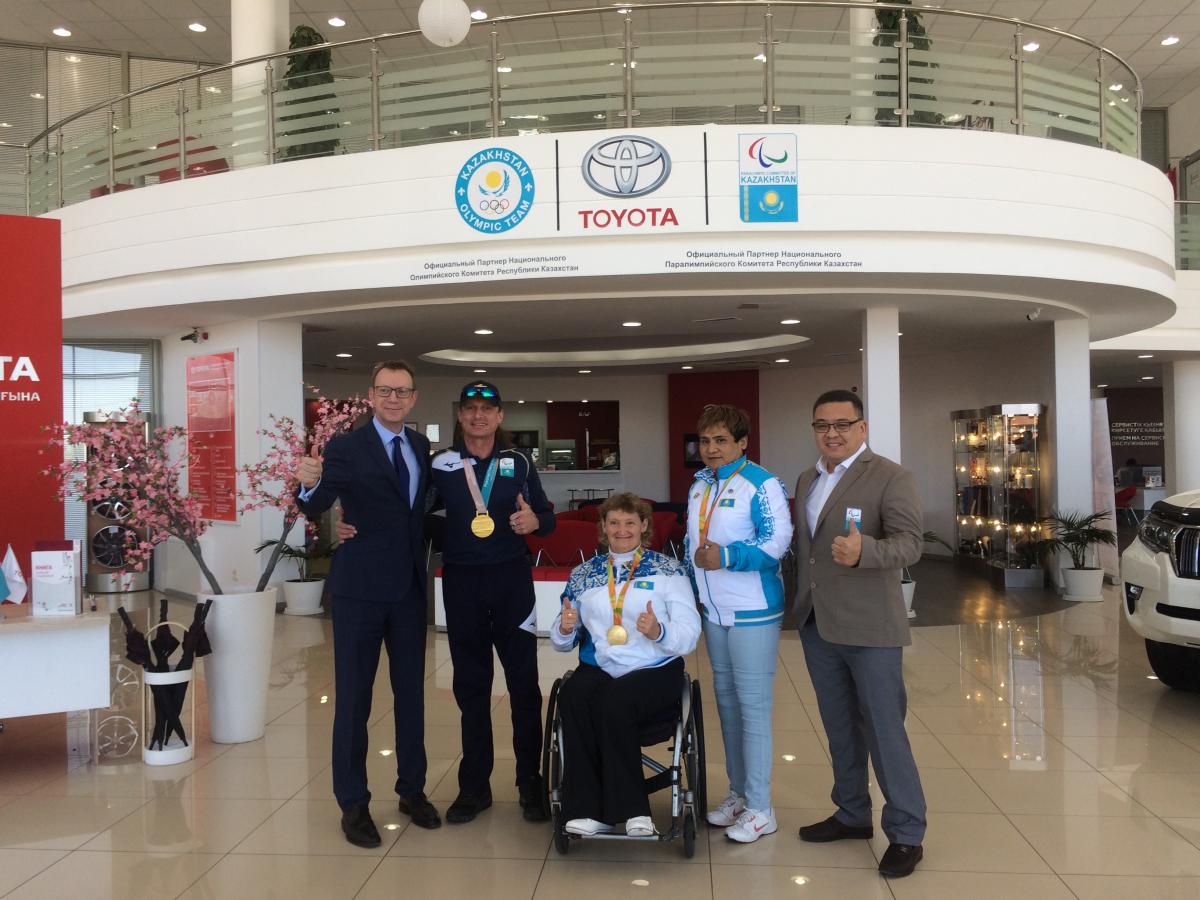 Toyota Kazakhstan a group of people standing in front of a Toyota sign