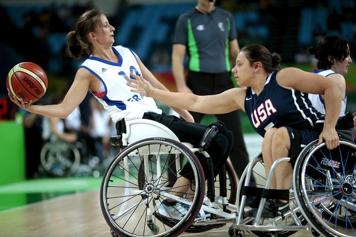 Marianne Buso - France - wheelchair basketball Woman in wheelchair holding a basketball while another tries to defend her
