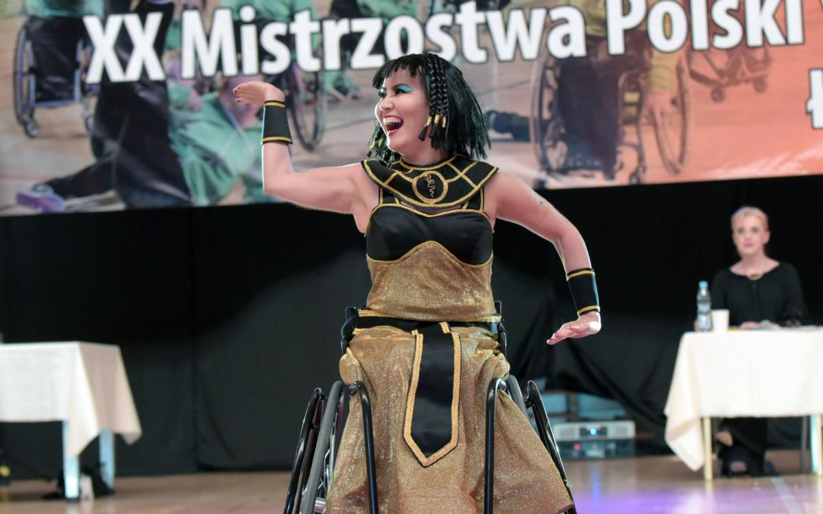 a female Para dance sport athlete strikes a pose dressed as Cleopatra