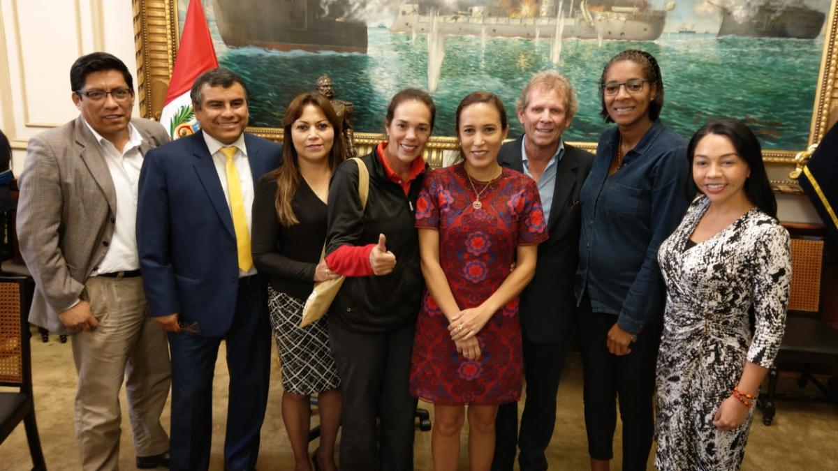 a group of people in a government office smiling at the camera