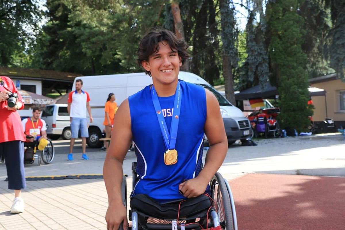 a male wheelchair athlete smiles for the camera
