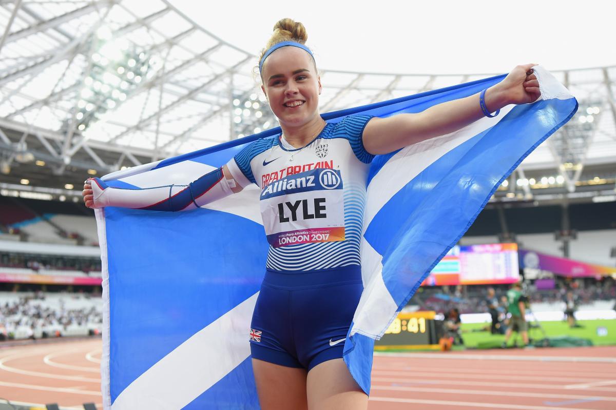 A female Para sprinter holding up a Scotland flag