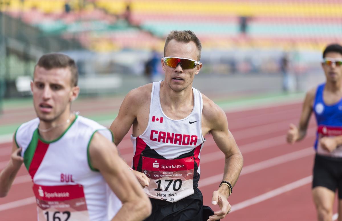 Nate Riech - 2018 Berlin Grand Prix a male Para athlete overtakes another runner on the track