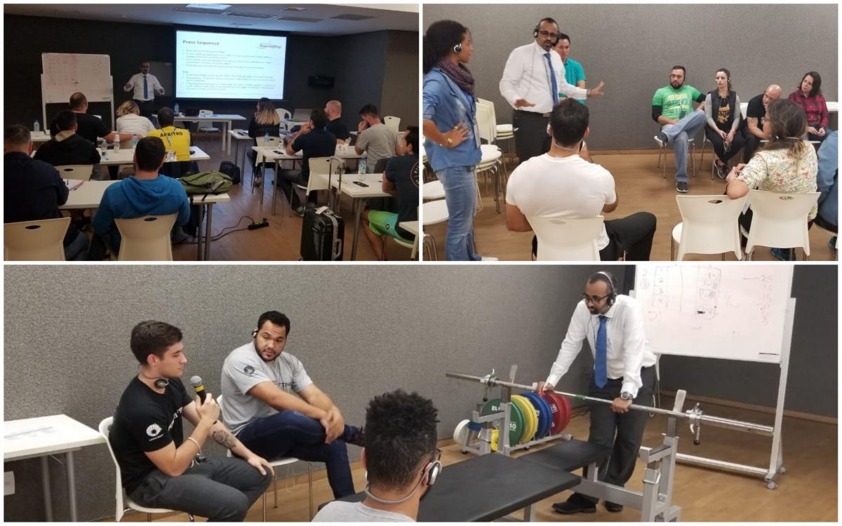 Brazil powerlifting officials course people in a room listening to a man talking and demonstrating a powerlifting bar