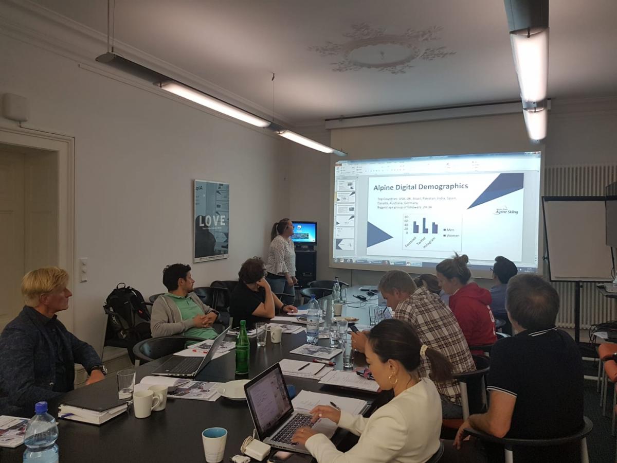 A group of people sitting watching a presentation on a screen