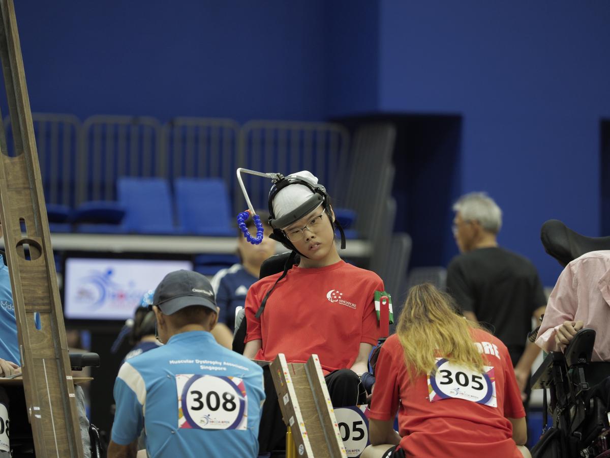 Boccia athlete Toh Sze Ning and her assistant get ready to roll ball down ramp