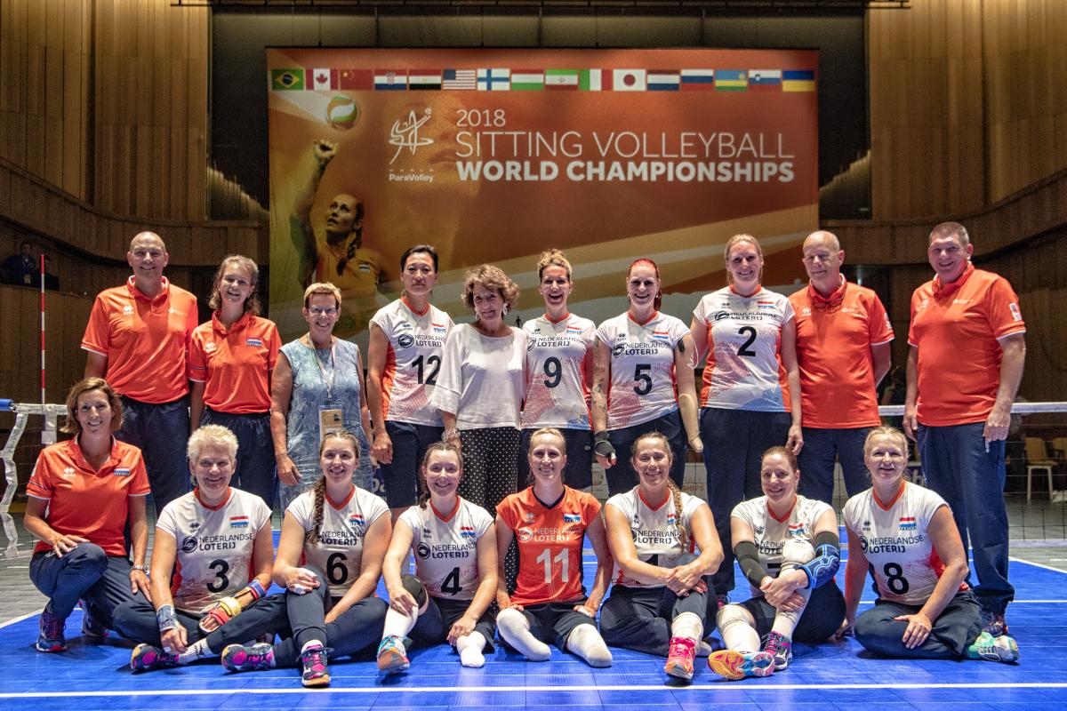 Princess Margriet and a group of female sitting volleyball players grouped together on a court