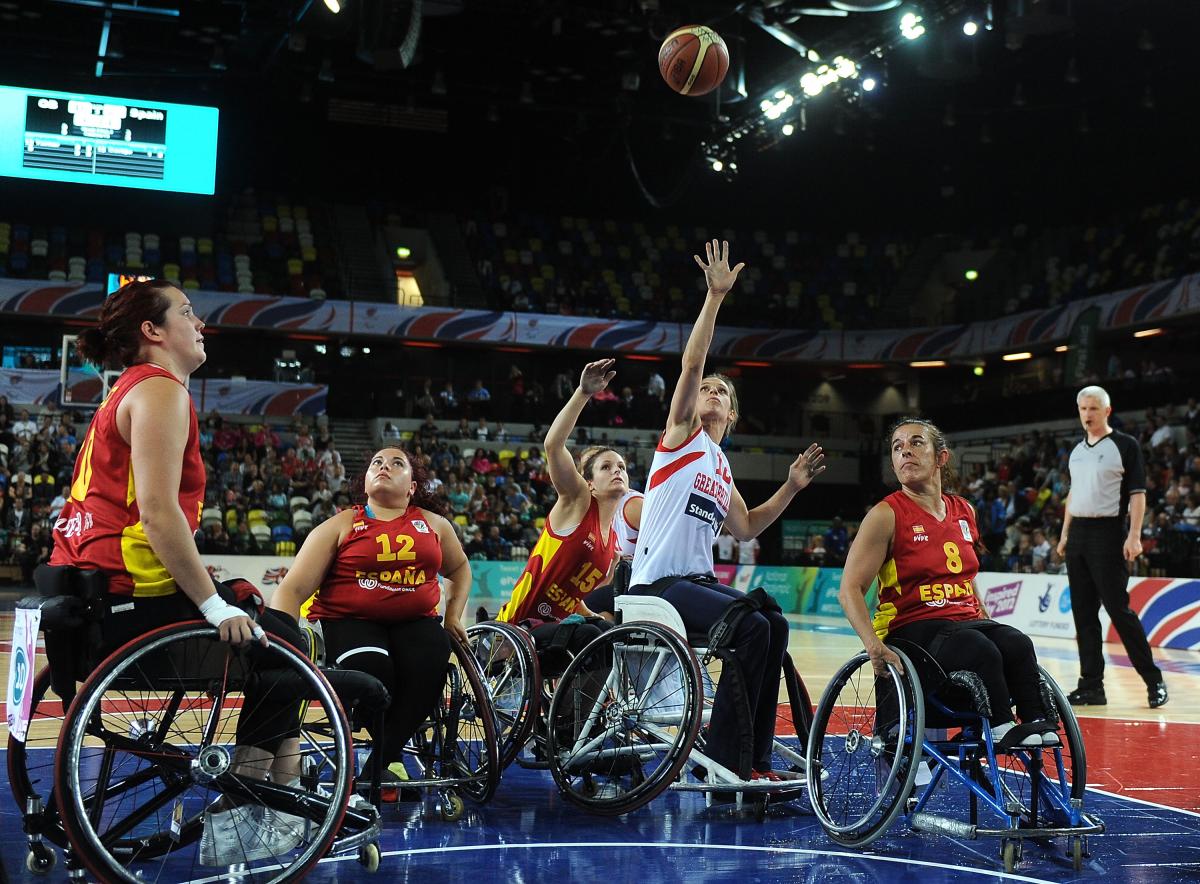 a group of female Spanish wheelchair basketballers fighting for the ball on the court