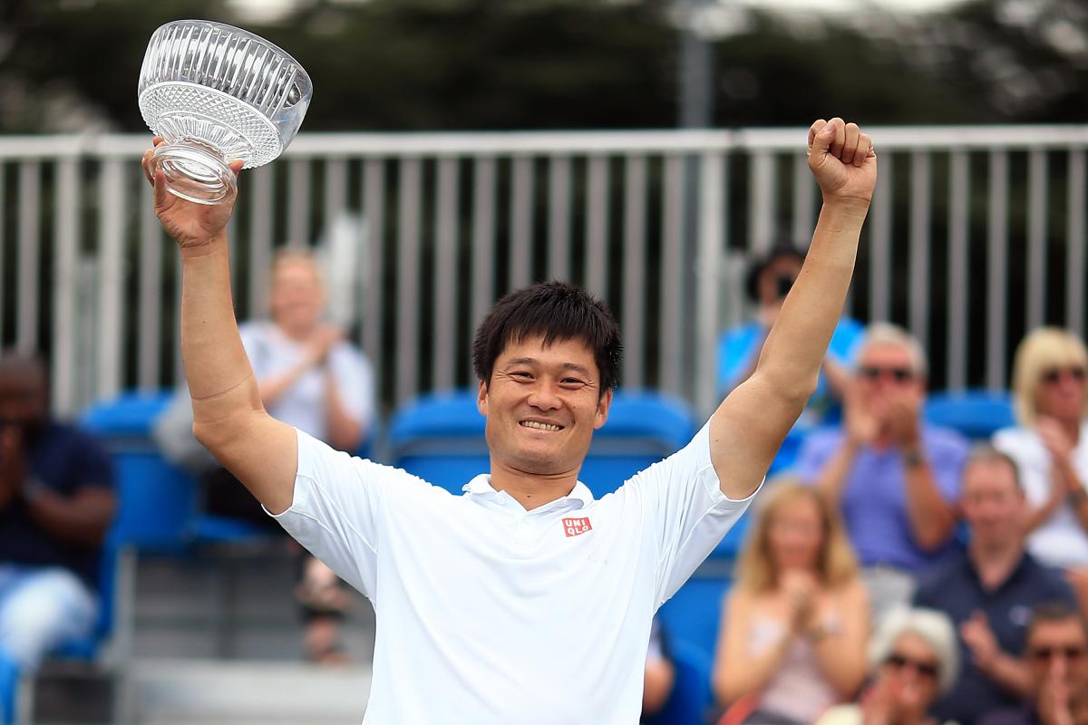 Male wheelchair tennis player Shingo Kunieda holds up a glass trophy