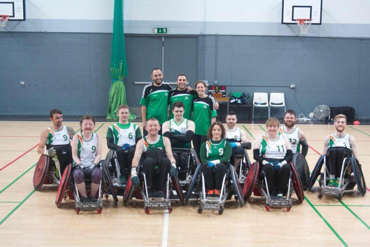 the Ireland male and female wheelchair rugby team smiling on a court