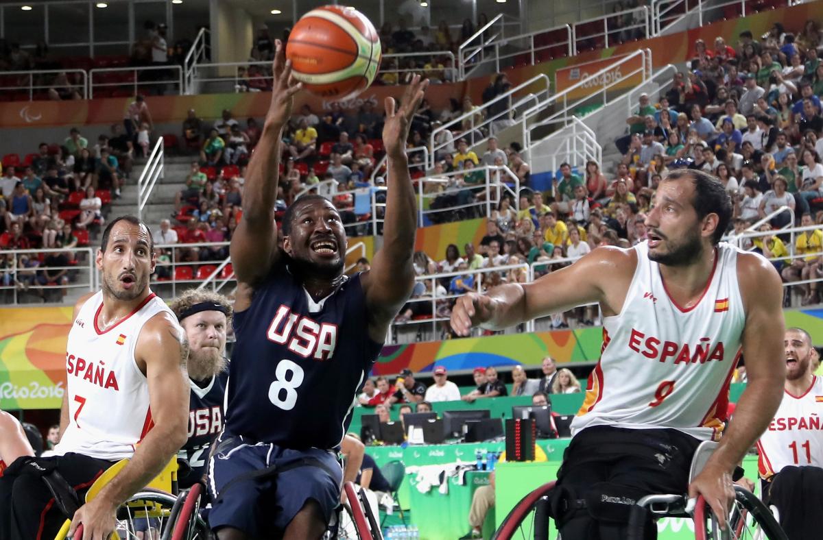 male wheelchair basketball players Alejandro and Pablo Zarzuela challenge a US player for the ball